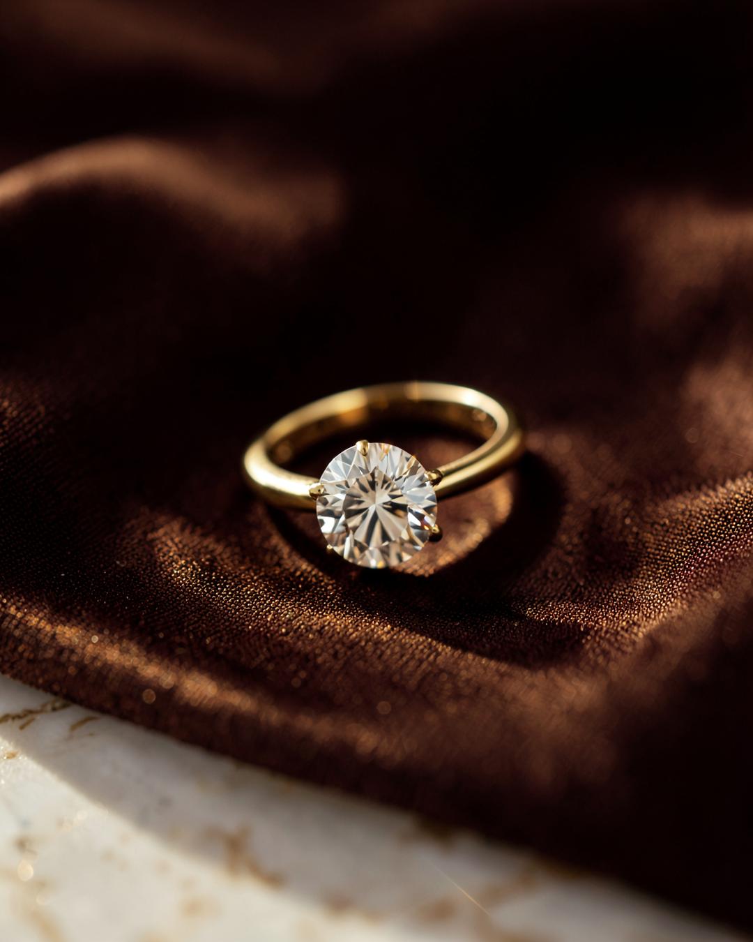 Sterling silver solitaire ring resting on rich chocolate-brown silk